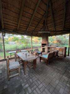 a patio with a wooden table and chairs and a fireplace at Lapa Lê Lê Lodge in Ellisras