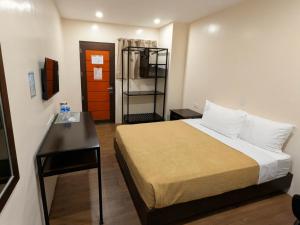 a hotel room with a bed and a desk and a room at Top Star Hotel Manaoag in Manaoag +1 photo