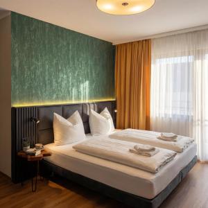 ein Schlafzimmer mit einem großen Bett und einer grünen Wand in der Unterkunft Wali's Hotel in Bielefeld + 31 Fotos