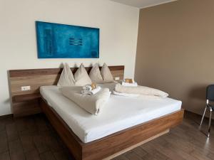 a large bed with white sheets and pillows on it at Frühstückspension Wernberg in Villach
