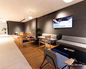 ein Wohnzimmer mit Sofa und Fernseher an der Wand in der Unterkunft Hotel Kalnik in Križevci