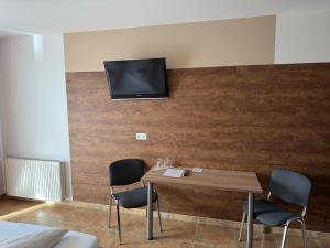 a room with a table and a tv on a wall at Frühstückspension Wernberg in Villach +8 photos