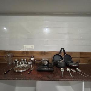 a kitchen counter with pots and pans on a stove at Simba Stay's 2BHK in Chikmagalūr