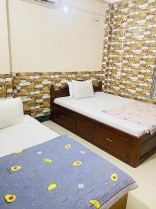 a room with two beds and a mattress with flowers on it at Jhapa damak in Kodudanga
