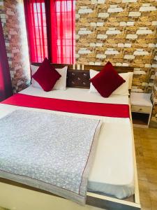 a large bed with red pillows in a room at Jhapa damak in Kodudanga