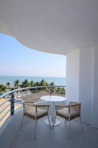 a table and two chairs on a balcony with the ocean at The Beach Bangsaen by Thanthita next to Wonnapa beach FREE DISNEY PLUS in Bangsaen