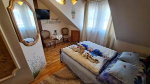 a bedroom with a bed and a mirror at Margaréta Panzió in Sárospatak
