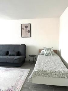 a bedroom with a bed and a couch at Apartman Stari Grad in Cazin