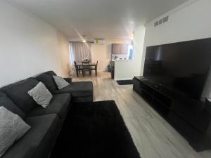 a living room with a couch and a large flat screen tv at Renovated Downtown Phoenix Condo in Phoenix
