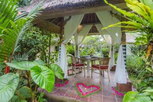 a porch of a house with a table and chairs at Chili Ubud Cottage in Ubud