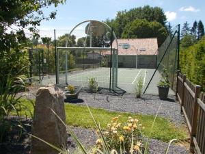 a tennis court with a mirror in a garden at L'olifred in Mathaux