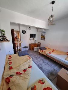 a room with two beds and a tv in it at Konak kod Daće in Drvar
