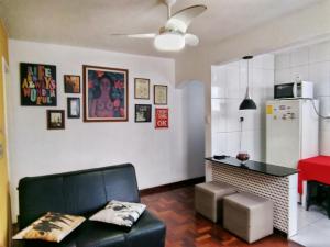 sala de estar con sofá y cocina con nevera. en Lindo Apartamento a 500m da Barra, en Salvador