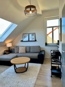 a living room with a couch and a table at Gästeapartment Schkeuditz Dachgeschoss in Schkeuditz