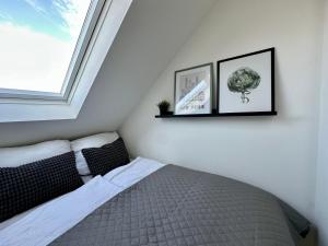 a bedroom with a bed with two pictures on the wall at Gästeapartment Schkeuditz Dachgeschoss in Schkeuditz