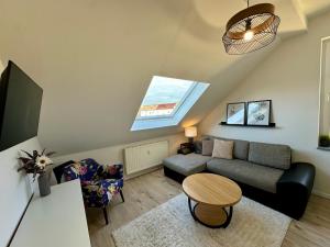 a living room with a couch and a table at Gästeapartment Schkeuditz Dachgeschoss in Schkeuditz +12 photos