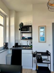 a kitchen with a black counter top and a microwave at Gästeapartment Schkeuditz Dachgeschoss in Schkeuditz