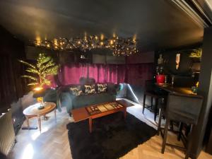 a living room with a couch and a table at Simons Whody Hideaway in Ulcombe +23 photos