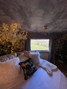 a bedroom with a bed with white sheets and a window at Simons Whody Hideaway in Ulcombe