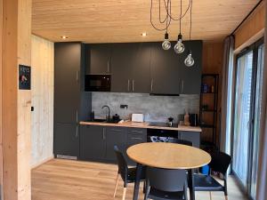 a kitchen with black cabinets and a table with chairs at Mountain View Home in Wysowa-Zdrój