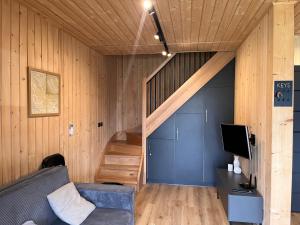 a living room with a couch and a staircase at Mountain View Home in Wysowa-Zdrój
