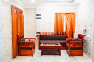 a living room with a couch and two chairs at Sumiwhitehouse in Vallam +1 photo