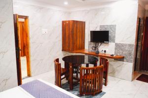 a dining room with a table and a tv at Sumiwhitehouse in Vallam