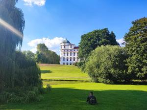 a boy sitting in the grass in front of a castle at Hehlentor Fachwerkwohnung in Celle