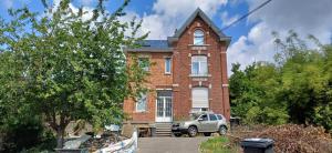 a brick house with a car parked in front of it at Belle chambre 2 in Seraing