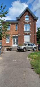 a car parked in front of a brick house at Belle chambre 2 in Seraing