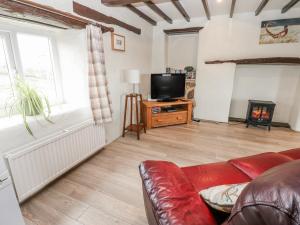 a living room with a red couch and a tv at The Granary in Ripon