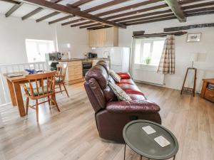 a living room with a leather couch and a table at The Granary in Ripon