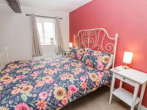 a bedroom with a bed with a floral bedspread at The Granary in Ripon
