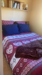 a bed with a red and white blanket on it at Ti caz prairie in Marnoz
