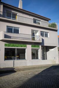 a white building with windows and a balcony at Bombarda 51 - Inn & Hostel in Vila Praia de Âncora