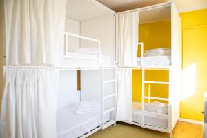 a white bunk room with white shelves and towels at Bombarda 51 - Inn & Hostel in Vila Praia de Âncora