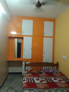 a bedroom with a bed and some white cabinets at Peter's villa in Kuttālam