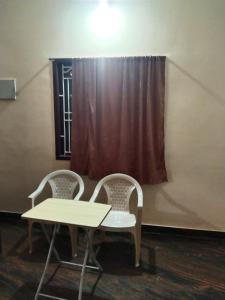 two chairs and a table in front of a window at Peter's villa in Kuttālam +1 photo