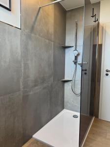 a bathroom with a shower with a glass door at Ferienwohnung Eifelhirsch in Ettringen +6 photos