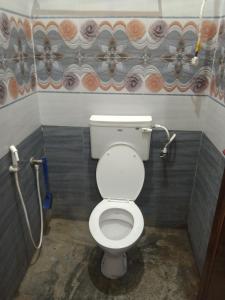 a bathroom with a white toilet in a stall at Peter's villa in Kuttālam