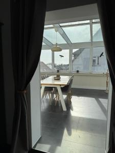 a dining room with a table and chairs and windows at Ferienwohnung Eifelhirsch in Ettringen