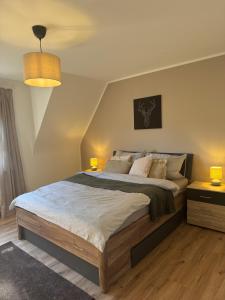a bedroom with a large bed and two lamps at Ferienwohnung Eifelhirsch in Ettringen