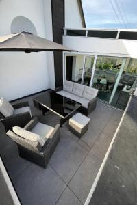 a patio with a table and chairs and an umbrella at Ferienwohnung Eifelhirsch in Ettringen