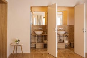 a bathroom with two sinks and two mirrors at Valle Benedetta Retreat Center in Livorno +119 photos