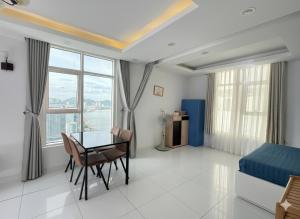 a bedroom with a desk and a bed and a table at Sunrise Sea View Apartment in Nha Trang