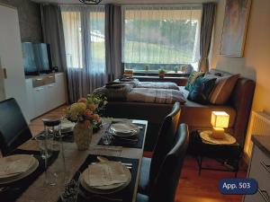 a living room with a bed and a table with chairs at Fewo Eisvogelnest in Sankt Englmar