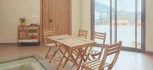 a wooden table and chairs in a room with a window at Zumi Stays in Udaipur