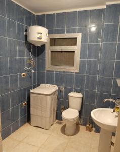 a bathroom with a toilet and a sink at شالية بقرية ريم الفلا in Dawwār Shindī Fannūsh