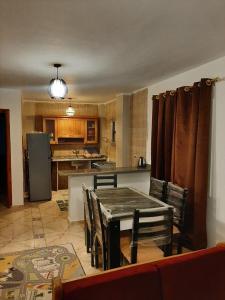 a kitchen with a table and chairs in a room at شالية بقرية ريم الفلا in Dawwār Shindī Fannūsh