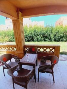 a table and chairs on a porch with a view at شالية بقرية ريم الفلا in Dawwār Shindī Fannūsh
